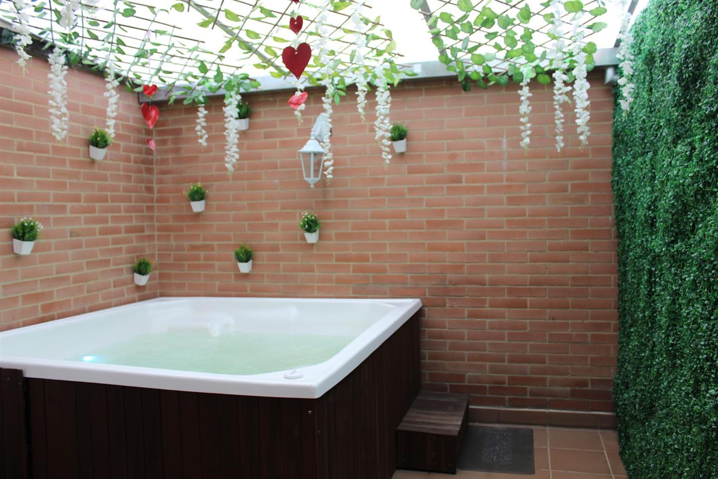 Jacuzzi con hidromasaje bajo enredaderas