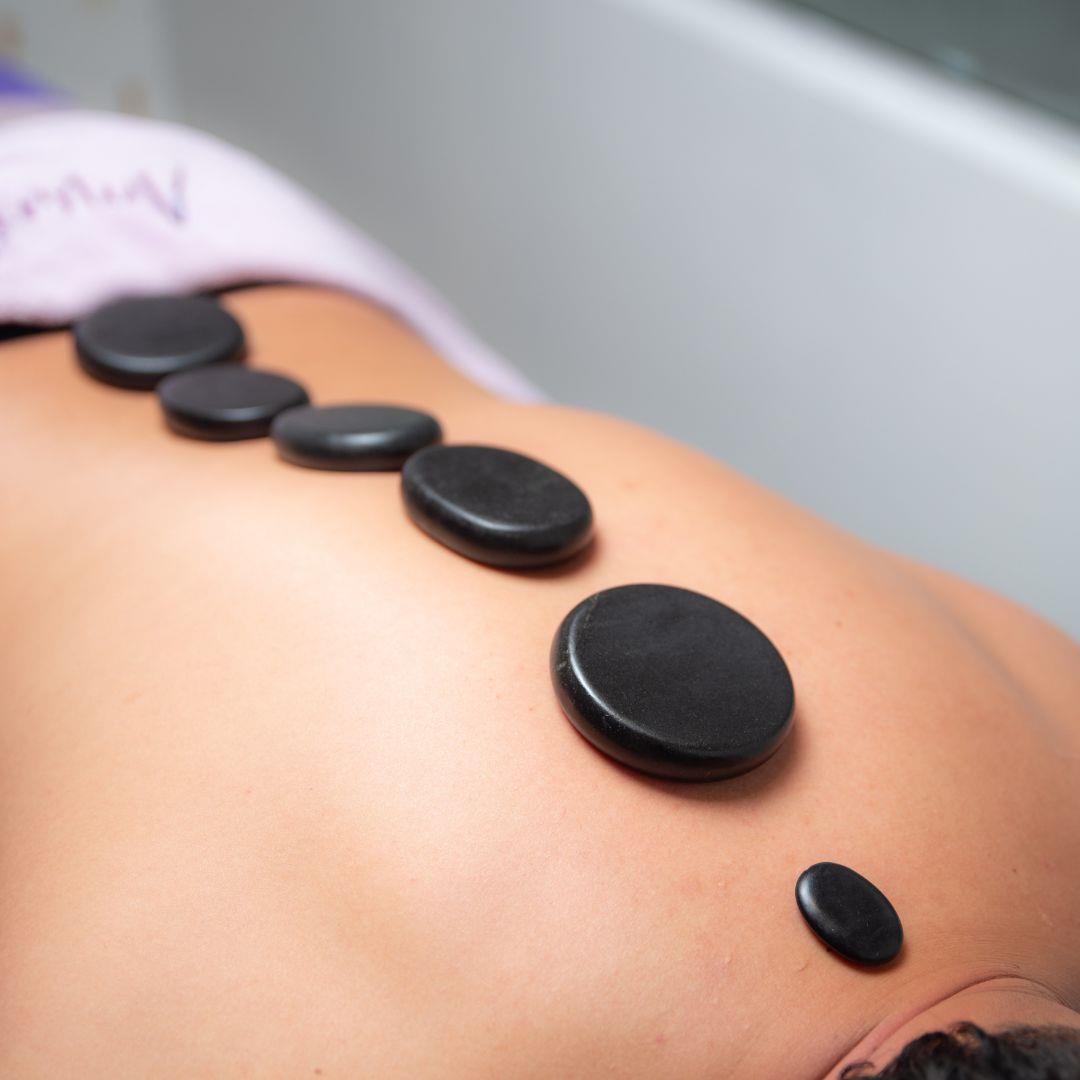 Masaje con piedras calientes sobre la espalda en Amarilis